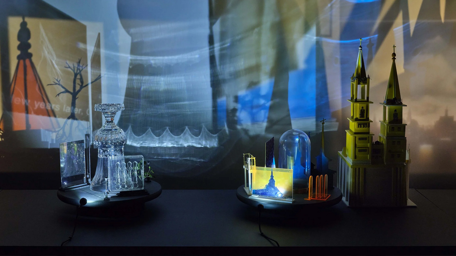 figures on a table casting shadows on the wall