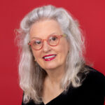 Picture of woman with white hair and red background.